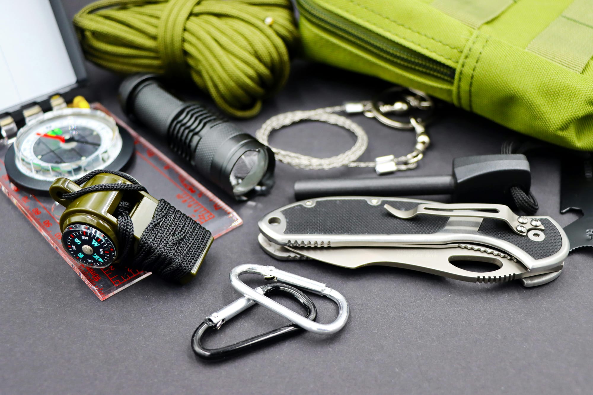 Knife, Carabiner clips, paracord, whistle, compass, flashlight. firestarter